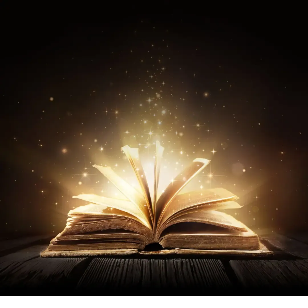 Open old book glowing with golden light and sparkles on a dark wooden table